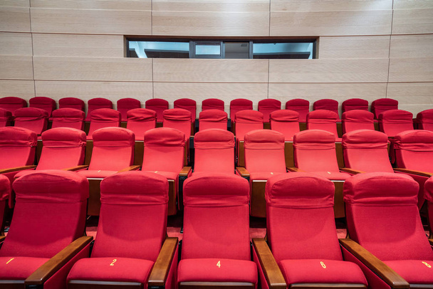 Σειρές κόκκινων καθισμάτων μέσα σε αίθουσα κινηματογράφου - Φωτογραφία, εικόνα