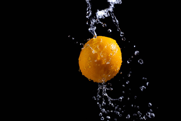 orange splash on black background - Fotó, kép