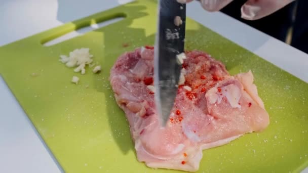 Työntekijät kaivertavat lihapaloja. Kädet hanskat leikata raakaa lihaa. lisäämällä valkosipulia
 - Materiaali, video