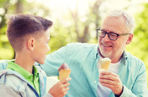 old man and boy eating ice cream at summer park - Photo, Image
