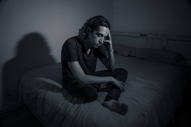 Devastated millennial man crying sad feeling hurt and hopeless suffering Depression. Depressed teenager victim of bullying or abuse sitting on bed alone in despair at night. In teenage Mental health. - Foto, Imagem