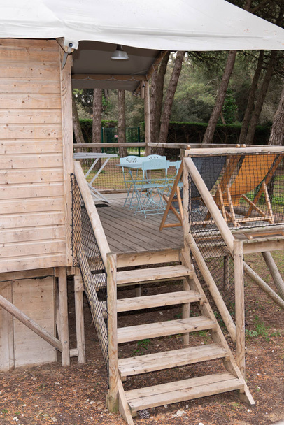 wooden staircase elevated wooden bungalow safari hut cabin chalet in camping park - Photo, Image