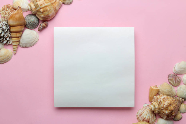 Marco de verano. Marco de papel para su texto y conchas marinas sobre un fondo rosa suave. vista superior
 - Foto, imagen