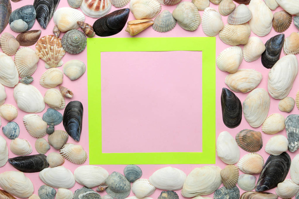 Moldura de verão. Moldura de papel para o seu texto e conchas em um fundo rosa suave. vista superior
 - Foto, Imagem