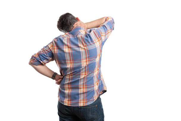 Man met terug naar camera aanraken nek - Foto, afbeelding