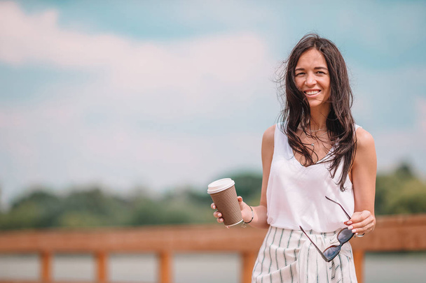 Happy young urban woman drinking coffee in european city. - Fotó, kép