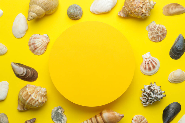 Marco de verano. Marco de papel para su texto y conchas marinas sobre un fondo amarillo brillante. vista superior
 - Foto, Imagen