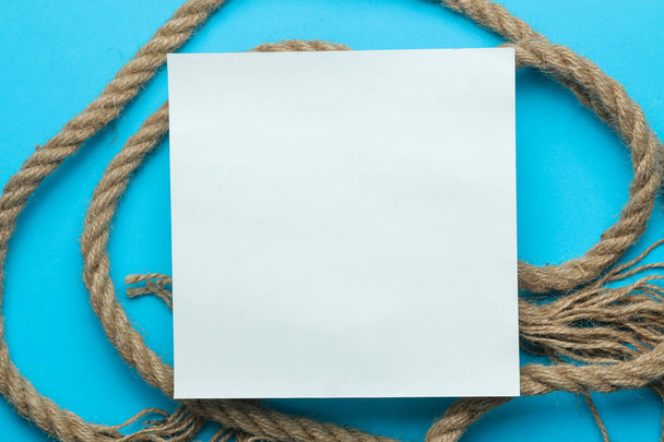 Moldura de verão. Moldura de papel para o seu texto e corda marinha em um fundo azul claro brilhante. vista superior
 - Foto, Imagem