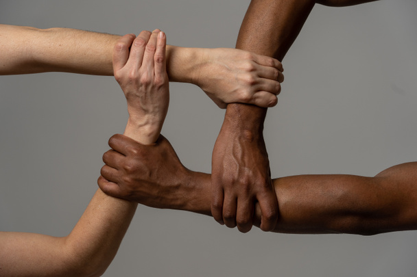 Races united against discrimination and racism. Black African American and Caucasian hands holding together in world unity and racial love and understanding. Tolerance and cooperation concept. - Foto, Imagem