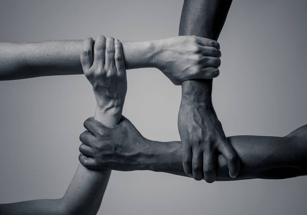 Races united against discrimination and racism. Black African American and Caucasian hands holding together in world unity and racial love and understanding. Tolerance and cooperation concept. - Zdjęcie, obraz