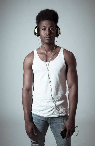 Artistic portrait of strong african american young dancer or DJ with headphones ready to play or dance in disco dance floor neon light in Internet Music festival and online music technology concept. - Foto, afbeelding