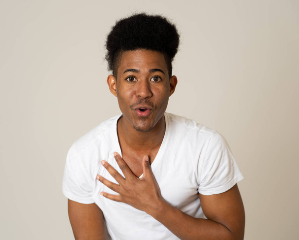Portrait of handsome shocked african american man pointing out and laughing with surprised and happy face. Teenager laughing at something funny. Facial Expression Human Emotions and Humor. - 写真・画像