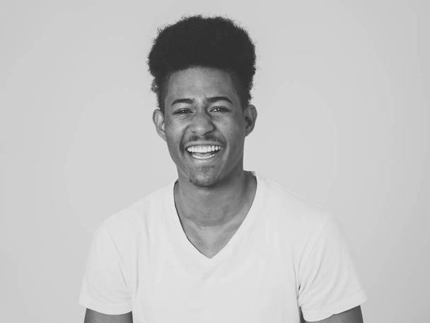 Portrait of happy african american man having fun and joy. Teenager smiling at the camera and looking to something that makes him laugh. In Human emotions facial expressions and youth happiness. - Foto, imagen