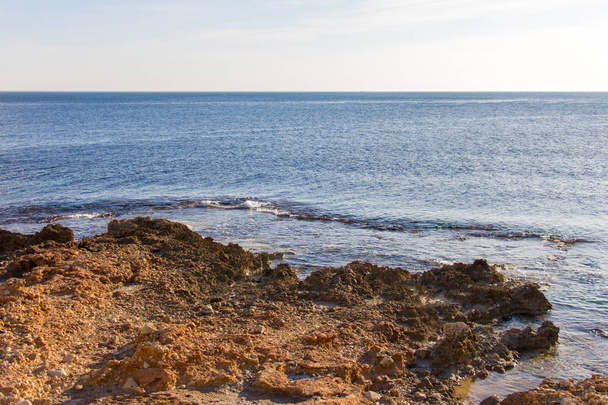Las Rotas praia rochosa em Denia, Espanha ao pôr do sol
 - Foto, Imagem