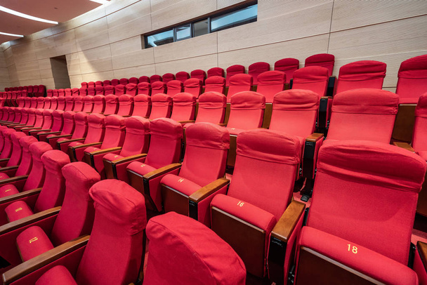 Filas de asientos rojos dentro de una sala de cine
 - Foto, Imagen