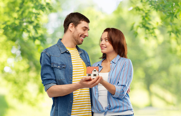 Sonriente pareja holding casa modelo
 - Foto, imagen