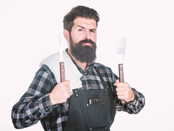 Barbecue master. Bearded hipster wear apron for barbecue. Roasting and grilling food. Man hold cooking utensils barbecue. Tools for roasting meat outdoors. Picnic and barbecue. Cooking meat in park - Foto, afbeelding