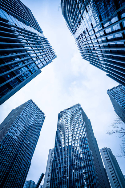 Вид снизу на современные небоскребы в деловом районе на фоне б
 - Фото, изображение