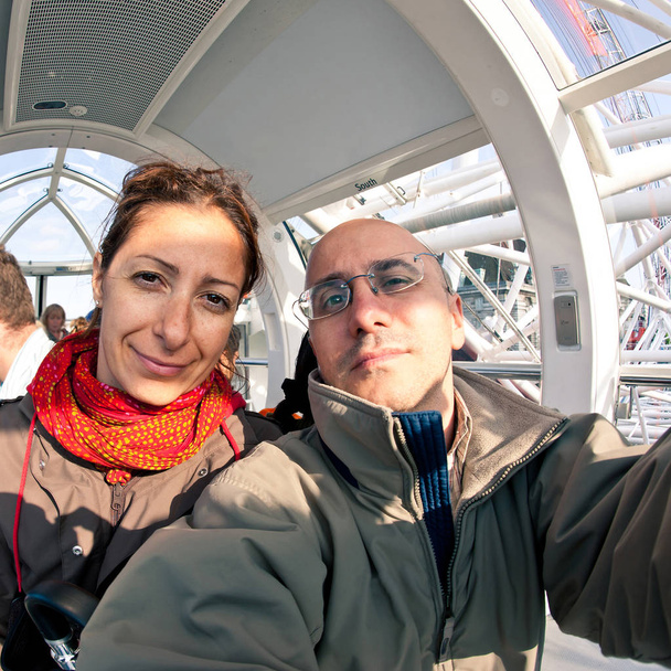 Couple inside London Eye's cabin. London Eye is the tallest Ferris wheel in Europe at 135 meters. - Photo, image