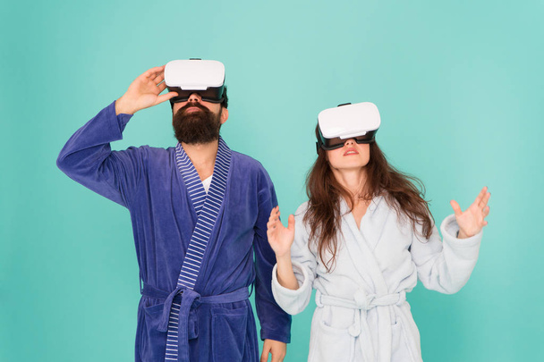 Looking upwards. Gaming and entertainment. Future closer than you think. Family explore VR at home. VR technology and future. VR communication. Exciting impressions. Couple bathrobes wear VR glasses - Φωτογραφία, εικόνα