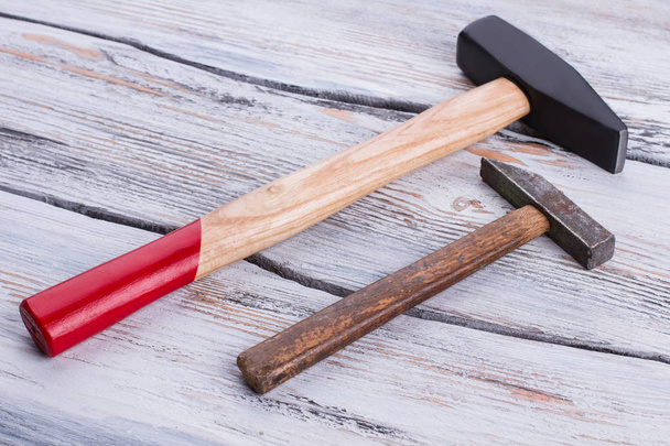 Old and new hammers on wooden background. - Photo, Image
