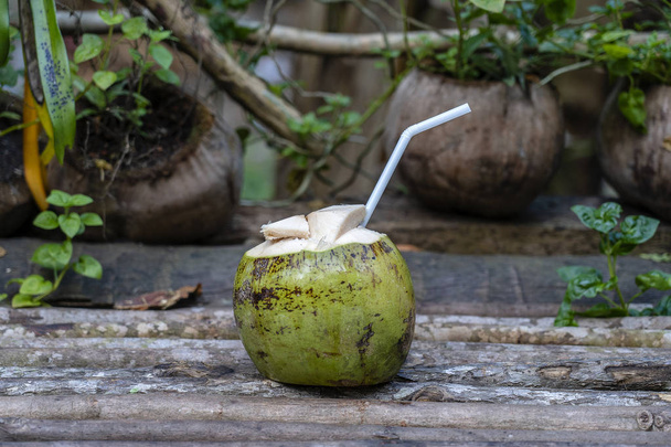 Sladká zelená kokosová voda s pitnou slámou na dřevěné desce. Thajsko. Zavřít - Fotografie, Obrázek