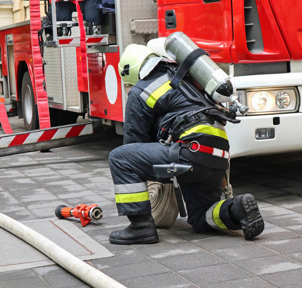 Pompiers travaille à côté d'un camion de pompiers
 - Photo, image