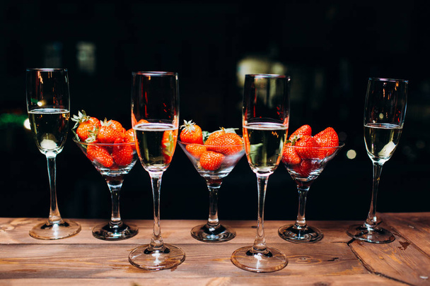 Champagne in a glass with strawberries in night. - Photo, image