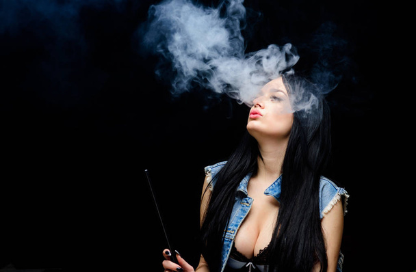 Vaping is sexy. Fashion girl vaping. Relaxing with hookah. Nicotine addiction. Attractive busty brunette smoking vaping device. Girl vaping. Hookah bar. Electronic cigarette. White cloud of smoke - Фото, изображение