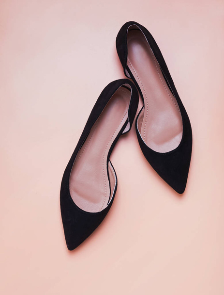 Feminine black suede shoese isolated on peach color background - Photo, image