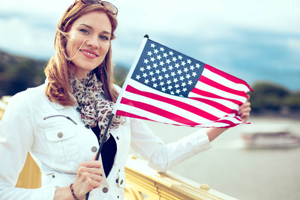 молода жінка тримає прапор США - Фото, зображення