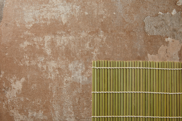 top view of green bamboo table mat on aged texture - Photo, Image
