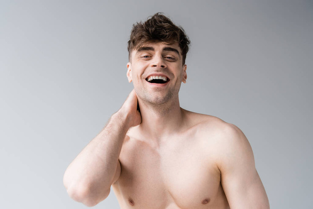 smiling shirtless sexy muscular man isolated on grey - Photo, image