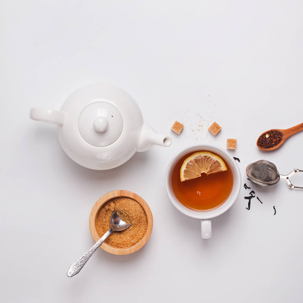 Bardak, çaydanlık ve şeker beyaz arka planda, üstten görünüm - Fotoğraf, Görsel
