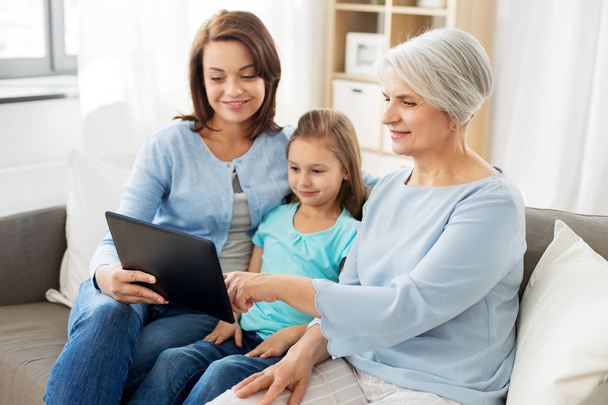 mother, daughter and grandmother with tablet pc - Фото, изображение