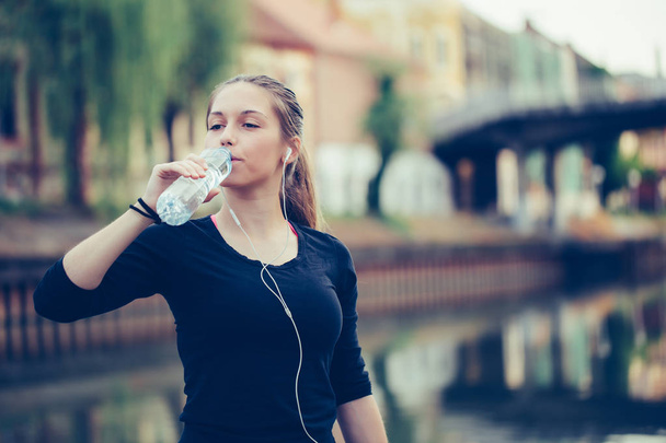 Фітнес спортсменка п'є воду після тренувань
 - Фото, зображення