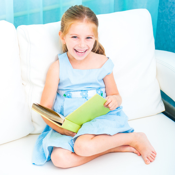 little girl reading a book - Фото, изображение