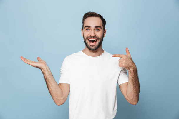 Cheerful excited man wearing blank t-shirt standing - Foto, Imagen