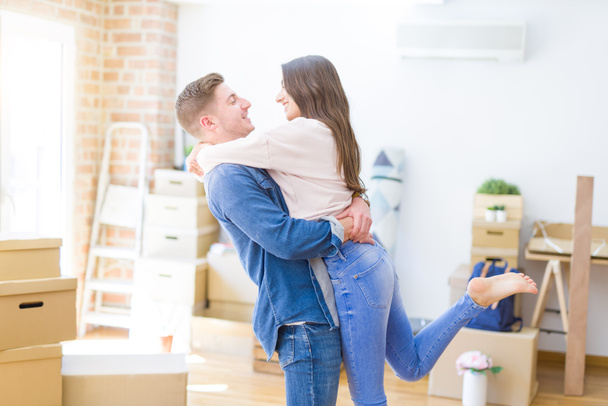Bonito jovem casal abraçando no amor, muito feliz movendo-se para uma nova casa
 - Foto, Imagem
