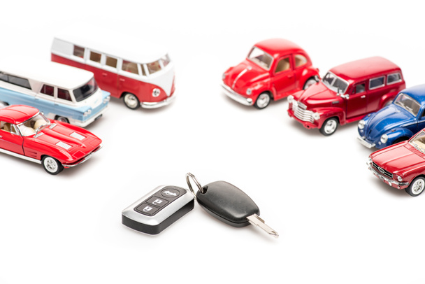 keys and colorful toy cars on white surface - Foto, Bild