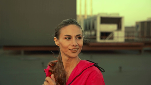 beautiful and smiling sportswoman running on rooftop - Footage, Video