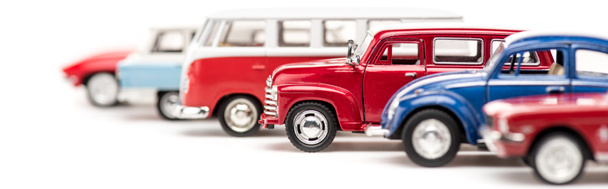 панорамный снимок красочных игрушечных автомобилей и автобуса на белом
 - Фото, изображение
