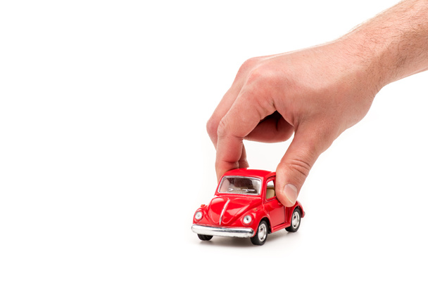 cropped view of man holding red toy car on white - Fotografie, Obrázek