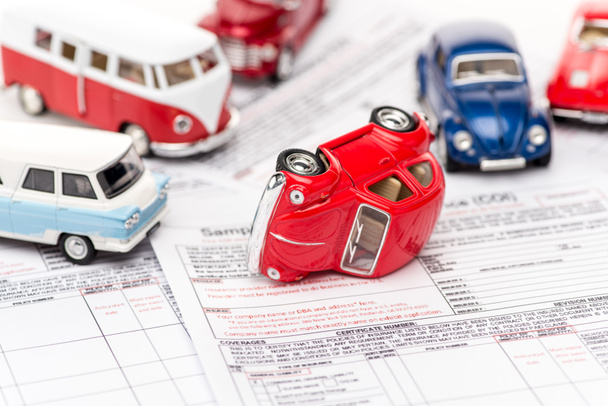 selective focus of colorful toy cars on insurance documents  - Fotó, kép