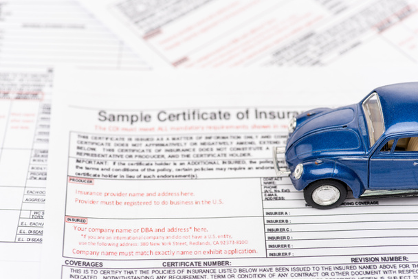 selective focus of insurance documents and blue toy car - Zdjęcie, obraz