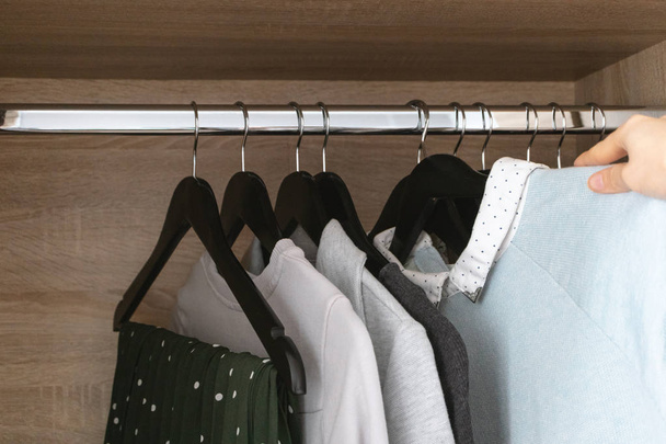 Female hand hangs clothes in wardrobe - Фото, изображение