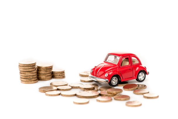 red toy car and golden coins on white - Fotó, kép