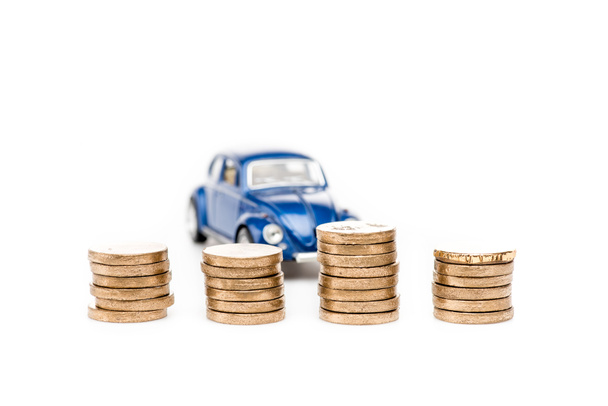 Szelektív összpontosítás érmék és kék játék autó fehér - Fotó, kép
