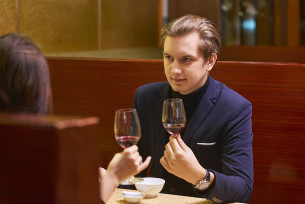 pareja en la fecha con copas de vino, tintineo vasos
 - Foto, Imagen