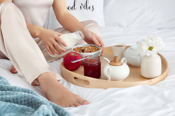 Mulher tendo saboroso café da manhã na cama
 - Foto, Imagem